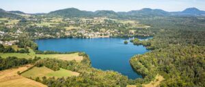 Vue aérienne du Lac d’Aydat entouré de forêts et de montagnes volcaniques en Auvergne