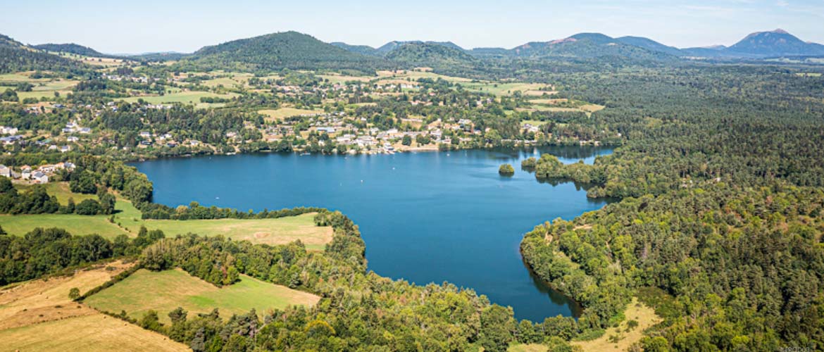 Vue aérienne du Lac d’Aydat entouré de forêts et de montagnes volcaniques en Auvergne