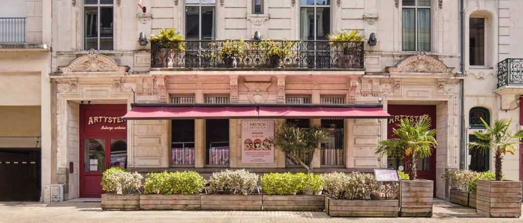 Façade de l'Hôtel Artyster au centre du Mans avec terrasse fleurie et architecture historique